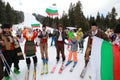 People dressed with traditional Bulgarian clothes skiing with the Bulgarian national flag. Royalty Free Stock Photo