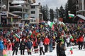 People dressed with traditional Bulgarian clothes skiing with the Bulgarian national flag. Royalty Free Stock Photo