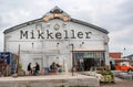 People drinking beer outside the popular bar with logo of Mikkeller brewery