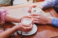 People drinking coffee in cafe, closeup of couple hands