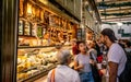 People drinking coffee in front of a cheese shop inside Queen Victoria Market aisle in Melbourne Australia