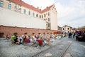 People drinking and sitting in sunbeds of street cafe in the old tram depot Royalty Free Stock Photo