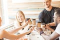 People, drinks, food concept - closeup of multiethnic friend taking coffee cups