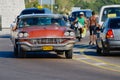 People drive vintage car in Havana, Cuba.