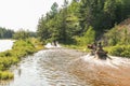People driving ATV quads through water. Lake in Ontario, Canada.