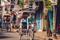 People driving bikes and walking down the street in a village in Kolkata, India Royalty Free Stock Photo