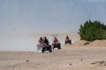 People driving quad bikes during safari trip in