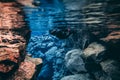 People snorkeling and diving in Blue crystal clear glacial water in Silfra Thingvellir national park Iceland