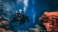 People snorkeling and diving in Blue crystal clear glacial water in Silfra Thingvellir national park Iceland