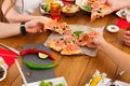 People eat pizza at festive table dinner party