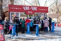 People eat on the street near a pizzeria called Chik-chik in Russian, in a city park in the spring