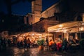 People eating and drinking at street restaurant in Rome.