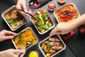 People eating from lunchboxes at grey table. Healthy food delivery Royalty Free Stock Photo