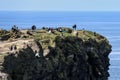 People at the edges of the Cliffs of Moher, located at the southwestern edge of the Burren region in County Clare, Ireland