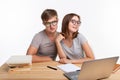 People and education concept - Two fallen in love funny students sitting at the wooden table with laptop and books Royalty Free Stock Photo