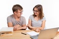 People and education concept - Two happy funny students sitting at the wooden table with laptop and books