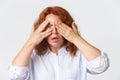 People, emotions and lifestyle concept. Close-up of shocked and alarmed redhead middle-aged woman cover eyes as being