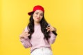 People emotions, lifestyle leisure and beauty concept. Stylish and cool young girl rapper in red cap, singing song and Royalty Free Stock Photo