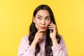 People emotions, lifestyle leisure and beauty concept. Thoughtful cute asian girl thinking while making phone call, book Royalty Free Stock Photo