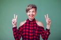 People and emotions - a portrait of happy woman showing peace sign with fingers Royalty Free Stock Photo