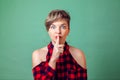 People and emotions - a portrait of woman with short dark hair with finger near lips showing hush silence sign Royalty Free Stock Photo
