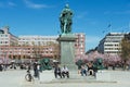 People enjoy lunchtime sitting under KARL XII statue at Kungstradgarden in Stockholm, Sweden. Royalty Free Stock Photo