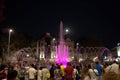 People enjoy pink illuminated fountain