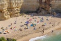 People enjoy the scenic beach at the Algarve coast near Carvoeiro and follow the rules for tourists at the beach according Corona