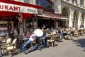 People enjoy sitting in the sun in the cafe