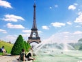 People enjoy sunshine and fountain pool in front of the Eiffel Tower