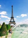 People enjoy sunshine and fountain pool in front of the Eiffel Tower