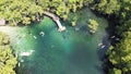 People enjoy swimming, jumping off deck to magnitude turquoise blue water of Morrison Springs County Park in Walton County,