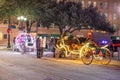 people enjoy to have a ride by night in the horse drawn carriage with colorful neon light in San Antonio at the river walk area