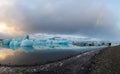 People enjoy the view of the icebergs floating in the water, blue ice reflects on the water