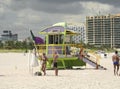 People enjoying beach by the Green and Purple Retro Style Lifeguard Hut at South Beach. August 28,2009 in Miami, Florida