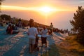 People enjoying beautiful sunset from the hillside view point over city