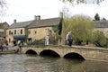 People enjoying at day by the River Windrush at Bourton on the Water in Gloucestershire, UK