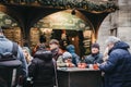 People enjoying festive drinks at Christmas market stall near St. Stephen Cathedral, Vienna, Austria. Royalty Free Stock Photo