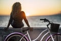 People enjoying outdoor leisure actvity looking a beautiful coloured sunset - woman with long curly blonde hair viewed from back