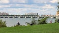 People enjoying the outdoors on Belle Isle with the iconic MacArthur Bridge in the background.