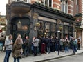 Typical pub with clients seated and standing outside in the city of London , England