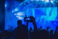 People enjoying rock concert and taking photos with cell phone at music festival Royalty Free Stock Photo