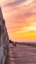 People enjoying a romantic evening on a pier overlooking the ocean and watching the stunning sunset