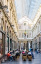 People enjoying the shops and sidewalk cafes in the Saint-Hubert Royal Galleries in Brussels, Belgium Royalty Free Stock Photo