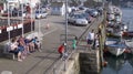 People enjoying some crab fishing from the harbour East Looe, Cornwall, UK