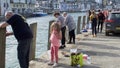 People enjoying some crab fishing from the harbour East Looe, Cornwall, UK