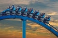 People enjoying the spectacular Mako roller coaster at Seaworld on a beautiful background of sunset sky.