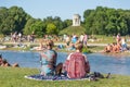 People tanning, swimming and enjoying the summer in Englischer Garten in Munich, Germany.