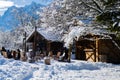 People enjoying sunbathing in snowy winter scenery outdoor wooden restaurant`s terrace
