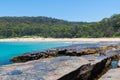 People enjoying the sunny weather at Pebbly Beach, a popular camping area with great surfing beach and bush walks within Royalty Free Stock Photo